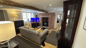 a living room with a couch and a fireplace at Stunning 4 Bed Peak Dist Farmhouse Alton Towers in Waterfall