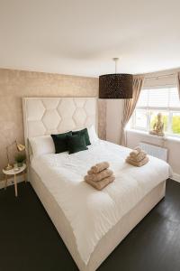 a bedroom with a large white bed with towels on it at 3BR Detached Home, Driveway & Large Rear Garden in Hogganfield +14 photos