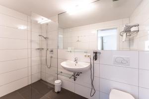 Kurpark Suites Bad Aibling في باد ايبلنغ: حمام أبيض مع دش ومغسلة +61 صورة