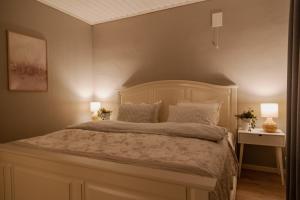 a bedroom with a large bed with two lamps at Apartment with exceptional view in Ålesund