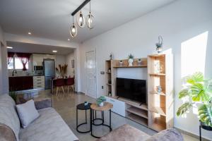 ein Wohnzimmer mit Sofa und Fernseher in der Unterkunft Villa Mazzeto Casa Alonia in Áno Yerakaríon