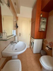 Un baño con lavabo y lavadora. en Vresthenisden, en Atenas 18 fotos más