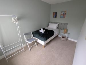 a bedroom with a bed and a chair and a lamp at Ruskin Apartment - Free Parking - 2 Bedrooms - Sleeps 3 in Midsomer Norton