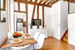 パリにあるLe Marais - Pont Marie - Paris Vacation Rentalsの食べ物が置かれたテーブルのあるダイニングルーム