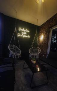a room with two hanging chairs and a sign on the wall at Villa Mali in Ferizaj +1 photo