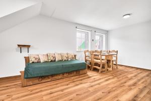 a living room with a couch and a table at Residence Koubek - stylové apartmány s parkováním in Boží Dar
