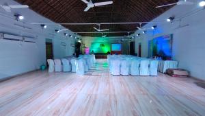 a room with a bunch of white chairs in it at Banalata Resort in Jaypur