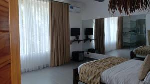 南威Ô TALIA Hôtel and SPA的一间卧室，里面有一张床和一扇大窗户。