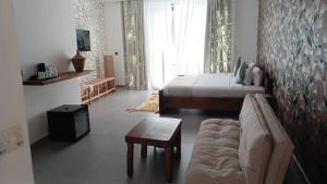 南威Ô TALIA Hôtel and SPA的一间带床、沙发和电视的卧室 更多35张照片