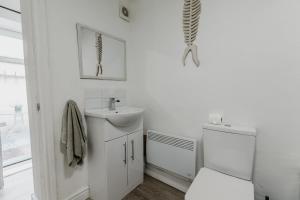 a white bathroom with a sink and a mirror at Withernsea 249 Stylish 2 Bed Apartment in Withernsea +6 photos