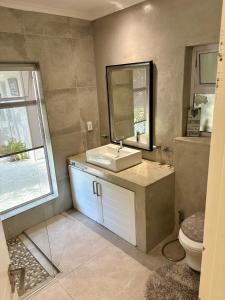 a bathroom with a sink and a mirror and a toilet at Bird Song Bedroom in Cape Town +7 photos