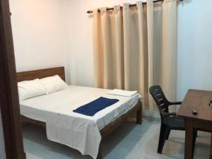 a bedroom with a bed and a table and a chair at Crystal house in Weligama +7 photos