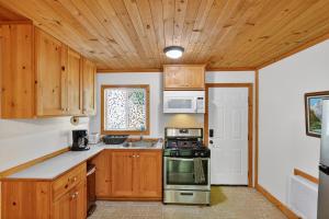 a kitchen with wooden cabinets and a stove top oven at Cozy Cabin Near Wineries, Harbin Hot Springs cabin in Cobb