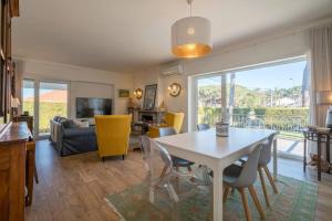 a living room with a white table and chairs at Charming Family Villa in Colares in Colares