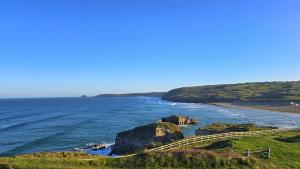 ein Blick auf das Meer mit einem Weg zu einem Strand in der Unterkunft 15 Penhale, Perranporth in Perranporth