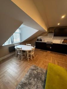 a room with a table and chairs and a kitchen at Stylish and Bright 1 Bedroom Flat in Wallasey +8 photos