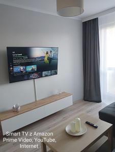 Una sala de estar con un televisor en la pared. en Apartament Park Podzamcze, en Olsztyn