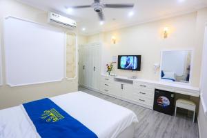 a bedroom with a bed and a tv in it at Platinum in Xóm Hương Phùng