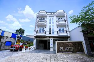 a white building with a sign in front of it at Platinum in Xóm Hương Phùng