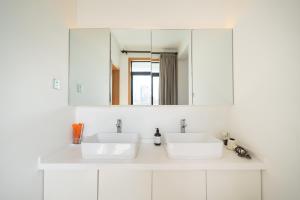 a white bathroom with two sinks and a mirror at ZHome - HaiQi Garden - Four Bedroom Apartment on the Bund with Bund View in Shanghai +34 photos