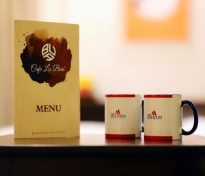 twee koffiemokken zitten op een tafel bij Hotel Meridien in Gujrānwāla