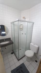 a bathroom with a shower and a toilet and a sink at Quartos Suítes Pousada, 4 min da Praia in Salvador