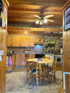 a kitchen with a table and a ceiling fan at Eria Moutoullas House in Moutoullas