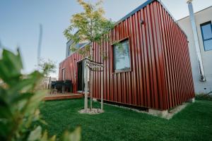 a red house with a small tree in the yard at Kolokemp pri súkromnom jazere Boldog in Senec +38 photos