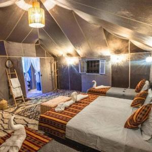 a room with three beds with swans on them at Camp luxury Merzouga in Merzouga