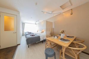a bedroom with a bed and a table and a bed at Joyful JUJO Stay 1minute walk from JR Jujo Station Shibuya 15min Shinjuku 11min Ikebukuro 6min Max 6guests 33square meters Simmons bed in Tokyo