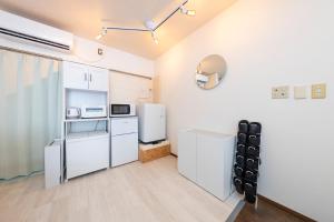 a kitchen with white cabinets and a refrigerator at Joyful JUJO Stay 1minute walk from JR Jujo Station Shibuya 15min Shinjuku 11min Ikebukuro 6min Max 6guests 33square meters Simmons bed in Tokyo