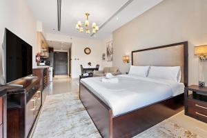 Un dormitorio con una cama grande y una sala de estar. en Chic Studio Near Burj Khalifa, en Dubái 25 fotos más