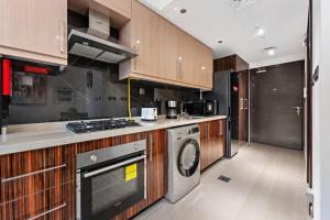 Una cocina con estufa, lavadora y secadora. en Chic Studio Near Burj Khalifa, en Dubái