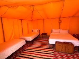 a room with three beds in a tent at Campement authentique désert d Agafay in El Moukhtar +15 photos