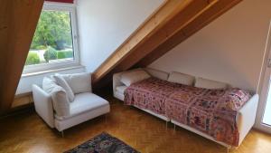 a bedroom with a bed and a chair and a window at Privatzimmer Freimann in Munich