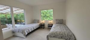 a bedroom with two beds and a table and windows at Modern Full Comfort Villa in Agnesberg