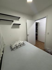 une chambre avec un lit avec un oreiller dessus dans l'établissement Apartamento Vagner, à Balneário Camboriú