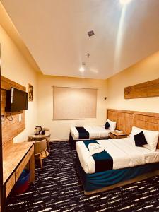 a hotel room with two beds and a flat screen tv at فندق درة النمارق المتميزة in An Naqāʼ