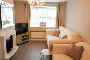 a living room with two couches and a television at The Townhouse Liverpool in Liverpool