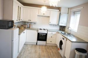 a kitchen with white cabinets and a washer and dryer at The Townhouse Liverpool in Liverpool +15 photos