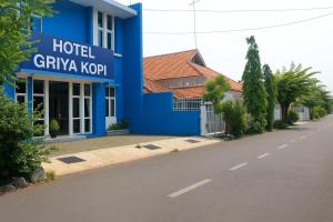 a blue hotel with a sign on the side of a road at Hotel Griya Kopi in Pekalongan