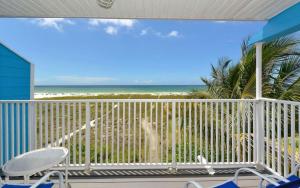 a balcony with chairs and a view of the beach at Happy Blue Coconuts - South in Siesta Key