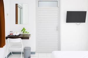 a white door in a room with a table and a chair at Hotel Griya Kopi in Pekalongan