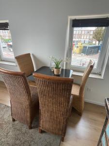 a dining room with a table and chairs and a window at Appartement Seepaardje in Scheveningen