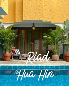 a villa with a swimming pool in front of a house at Riad Hua Hin in Hua Hin