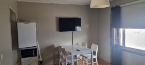einen Esstisch mit Stühlen und einen TV an der Wand in der Unterkunft Sackleninkatu in Pori