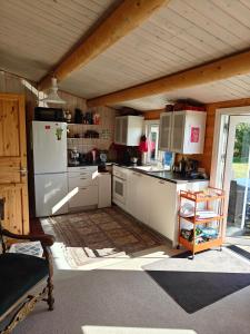 a kitchen with a white refrigerator in a room at Charmerende Norsk Bjælkehytte med fibernet in Slagelse +10 photos