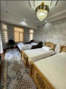a bedroom with four beds and a chandelier at Guesthouse Anora 1, Three minutes walk from Registan Square, The very Center of Samarkand in Samarkand