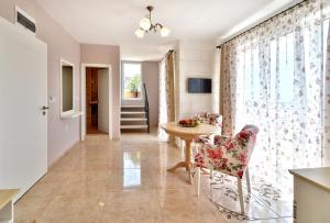 a living room with a table and chairs and a window at Sirena Palace Family Hotel in Obzor