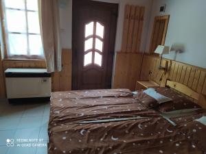 エゲルサロークにあるFanni Apartmanのベッドと窓とドアのある寝室